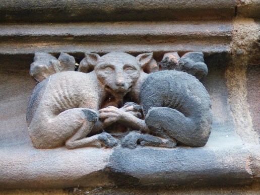 two carved stone cratures share the same face